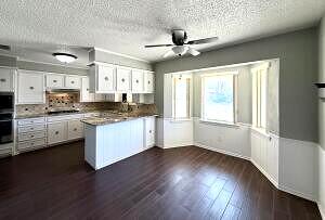 3206 77th Street Lubbock, TX 79423 - Photo 7 of 35 a view of a kitchen with a sink wooden floor and windows