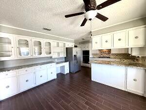 3206 77th Street Lubbock, TX 79423 - Photo 9 of 35 a large kitchen with granite countertop a large window a sink and stainless steel appliances
