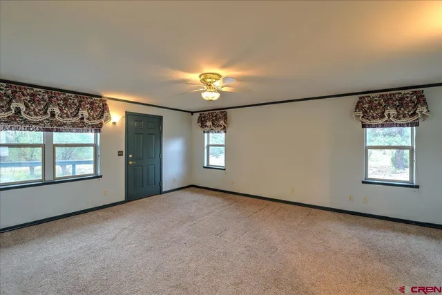 an empty room with a window and ceiling fan