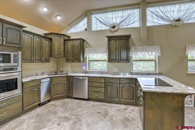 a kitchen with stainless steel appliances granite countertop a sink and stove
