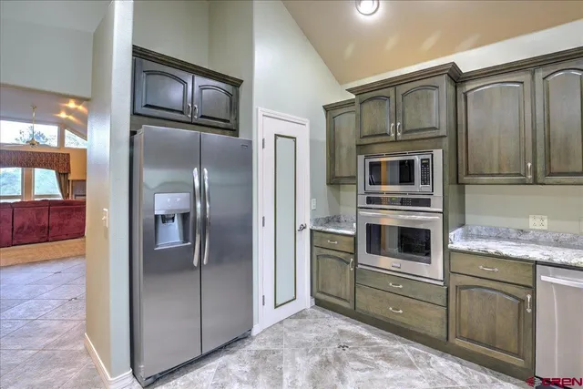 a kitchen with granite countertop a refrigerator and cabinets
