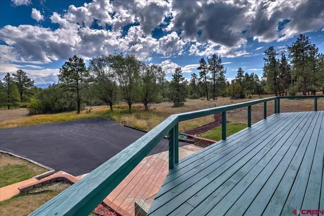 a view of a balcony with wooden floor and fence