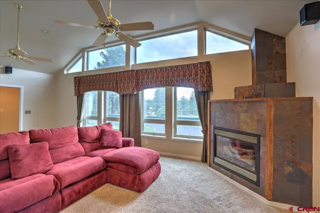 a living room with furniture a ceiling fan and a fireplace