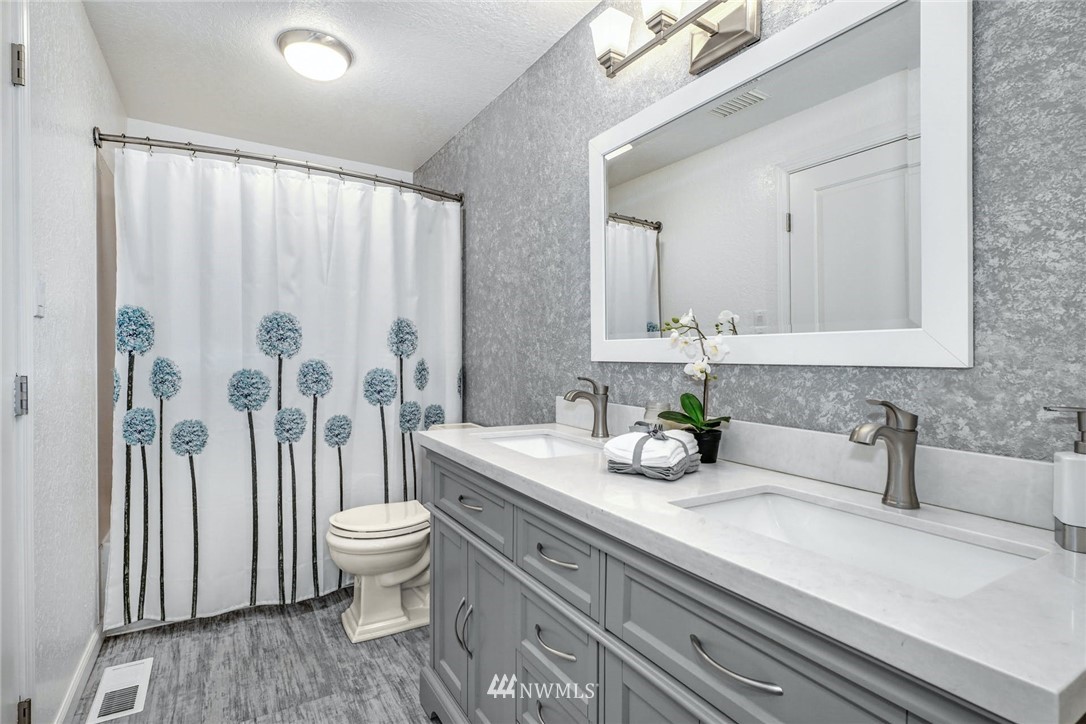 17409 29th Drive Southeast Bothell, WA 98012 - Photo 19 of 37 a bathroom with a granite countertop sink a toilet and a mirror