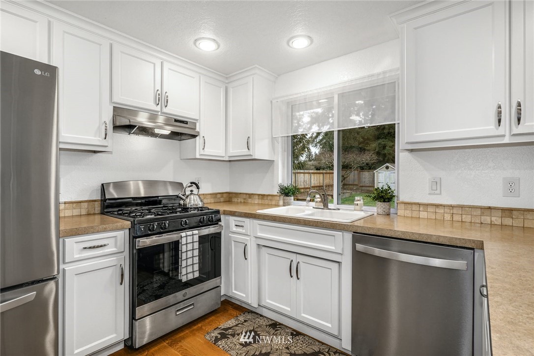 17409 29th Drive Southeast Bothell, WA 98012 - Photo 10 of 37 a kitchen with stainless steel appliances granite countertop a stove a sink and a refrigerator