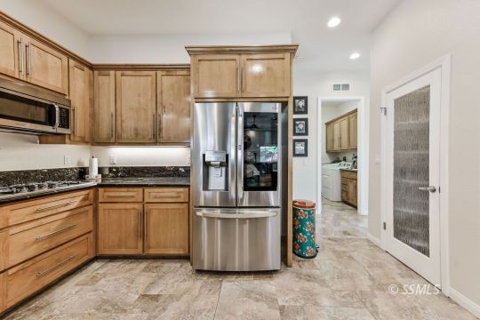 1213 Carolyn Street Ridgecrest, CA 93555 - Photo 11 of 50 a kitchen with stainless steel appliances granite countertop a refrigerator and a stove top oven