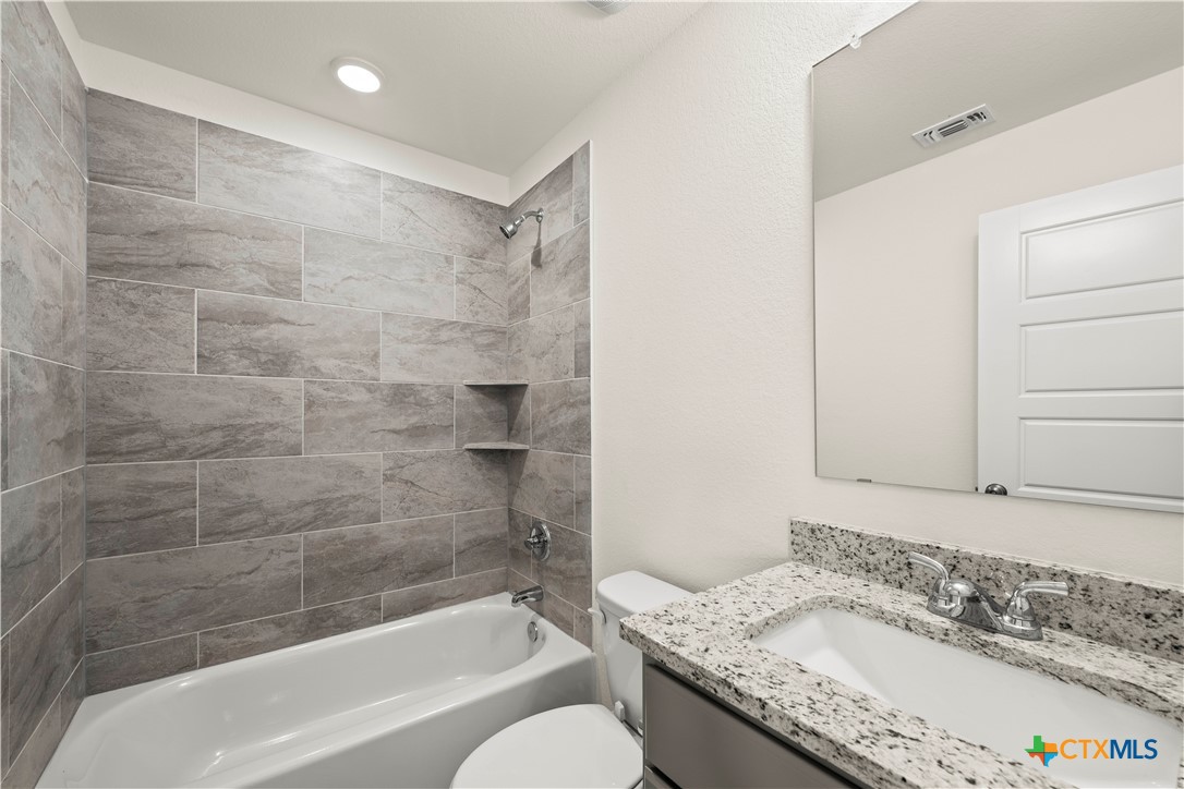5102 Pollack Lane Belton, TX 76513 - Photo 11 of 30 a bathroom with a granite countertop bathtub shower sink vanity and toilet