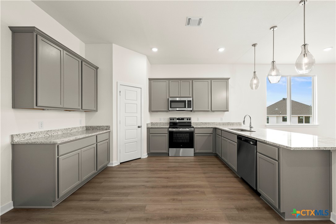 5102 Pollack Lane Belton, TX 76513 - Photo 21 of 30 a large kitchen with stainless steel appliances granite countertop a stove and a sink