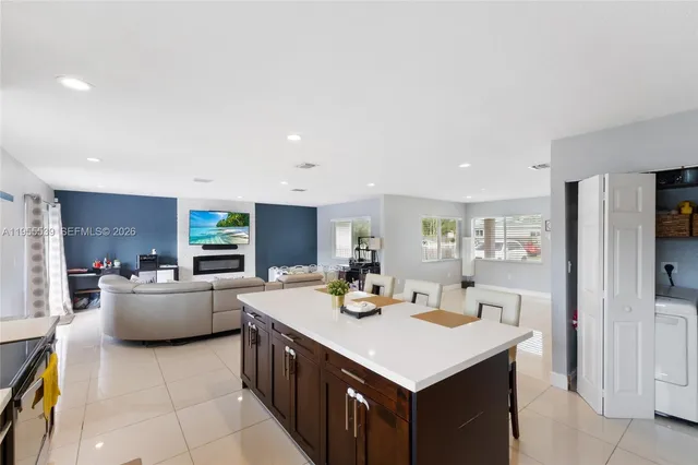 a kitchen with a sink counter top space and living room