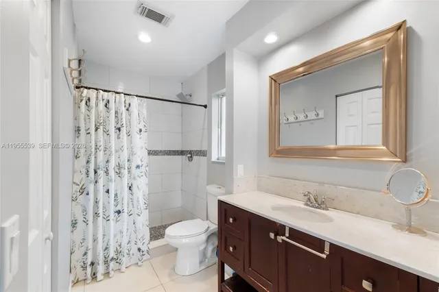 a bathroom with a sink toilet double vanity and shower