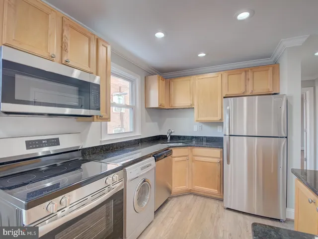 a kitchen with a refrigerator a sink and cabinets