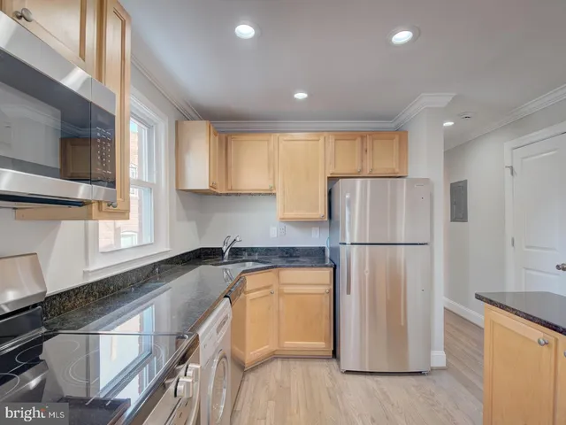 a kitchen with a refrigerator a sink and cabinets