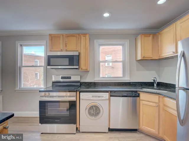 a kitchen with granite countertop white cabinets and white appliances