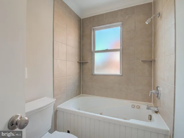 a white bath tub sitting next to a white toilet