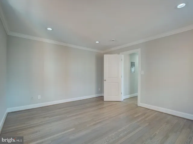 a view of an empty room with wooden floor