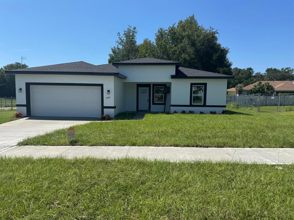 3862 Southwest 147th Street Ocala, FL 34473 - Photo 1 of 29 a front view of a house with a yard and garage