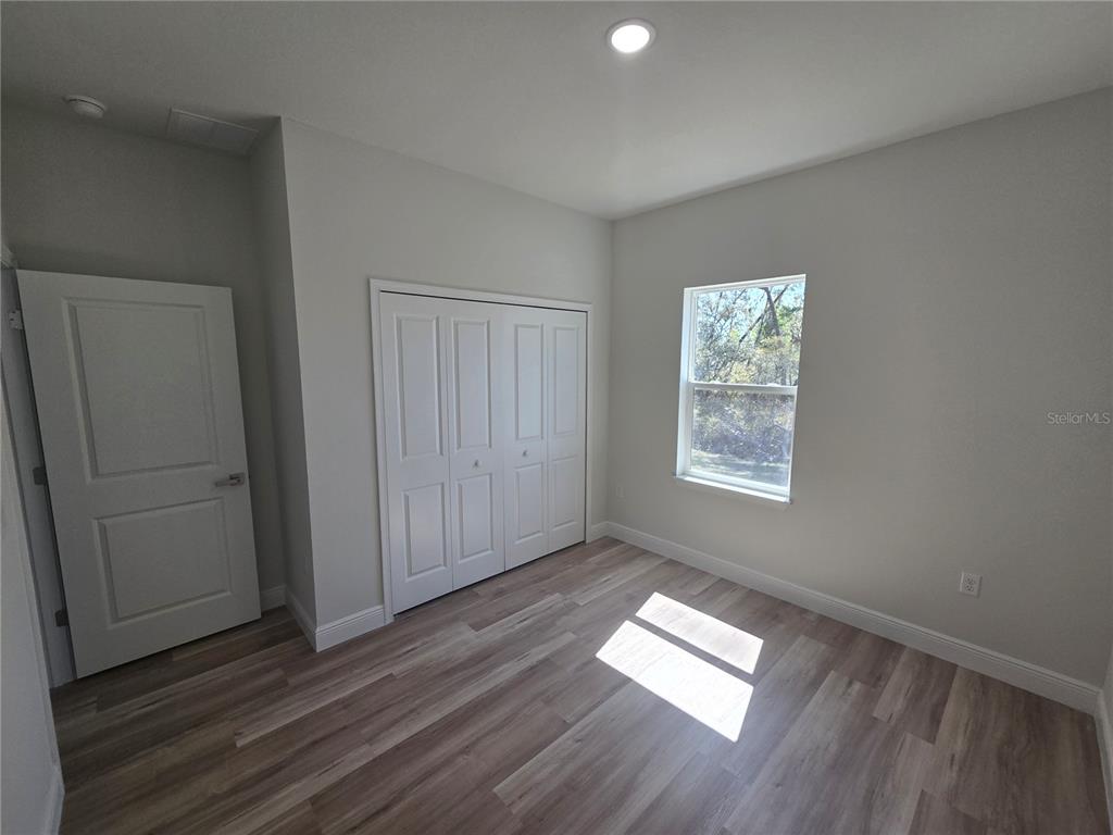 3862 Southwest 147th Street Ocala, FL 34473 - Photo 15 of 29 an empty room with wooden floor and windows