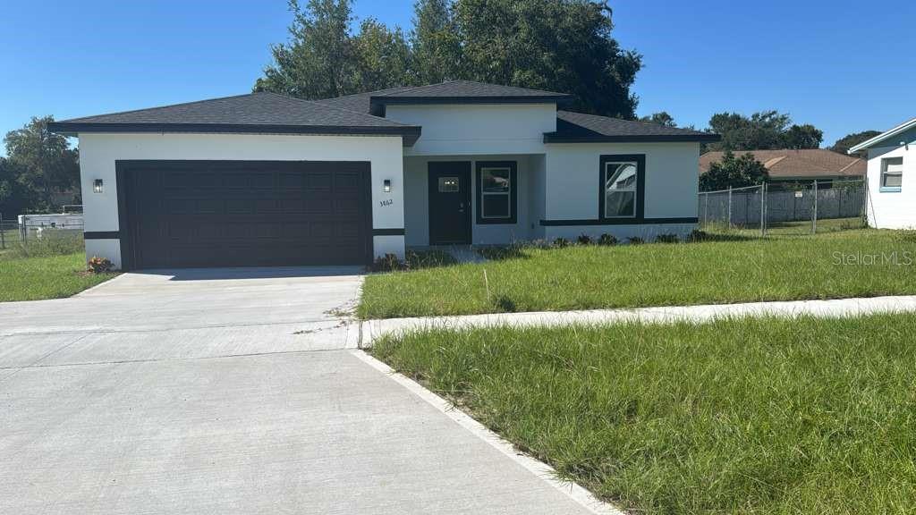 3862 Southwest 147th Street Ocala, FL 34473 - Photo 2 of 29 a front view of a house with a yard and garage