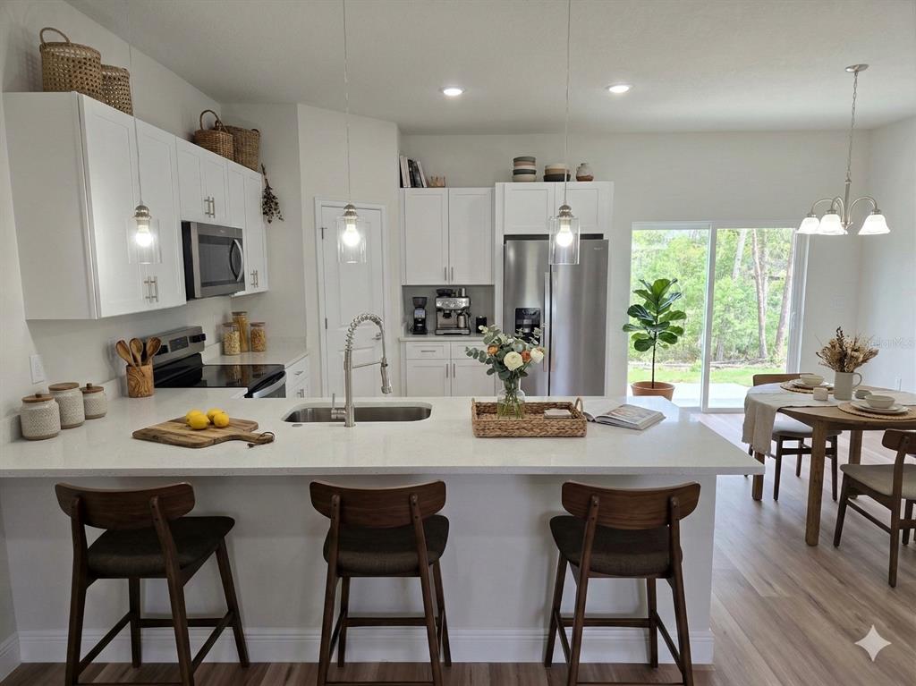 3862 Southwest 147th Street Ocala, FL 34473 - Photo 7 of 29 a kitchen with a dining table chairs and microwave
