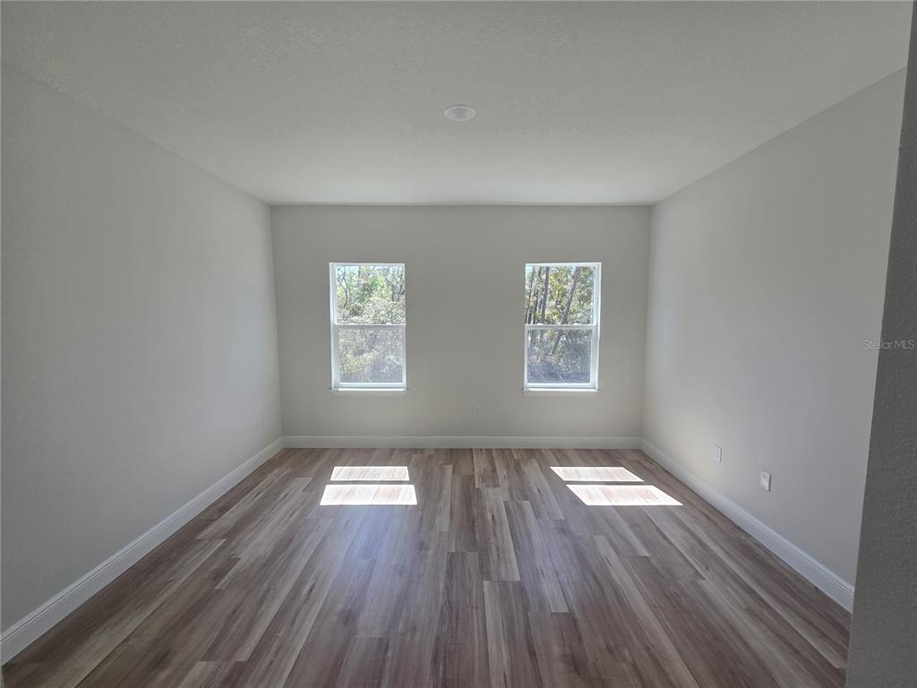3862 Southwest 147th Street Ocala, FL 34473 - Photo 9 of 29 an empty room with wooden floor and windows