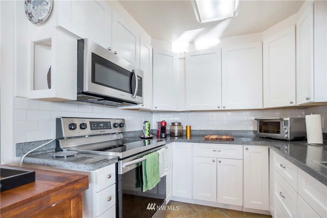 731 Woodmont Beach Road South Des Moines, WA 98198 - Photo 10 of 40 a kitchen with stainless steel appliances granite countertop a sink dishwasher stove and cabinets with wooden floor