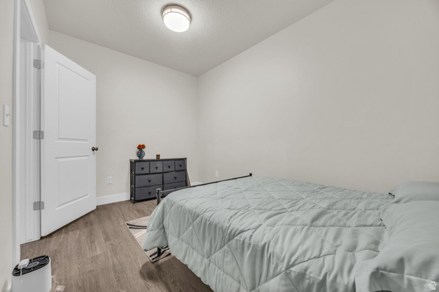 2101 North Main Street, Unit 409 Sunset, UT 84015 - Photo 10 of 18 Bedroom featuring wood finished floors and a textured ceiling