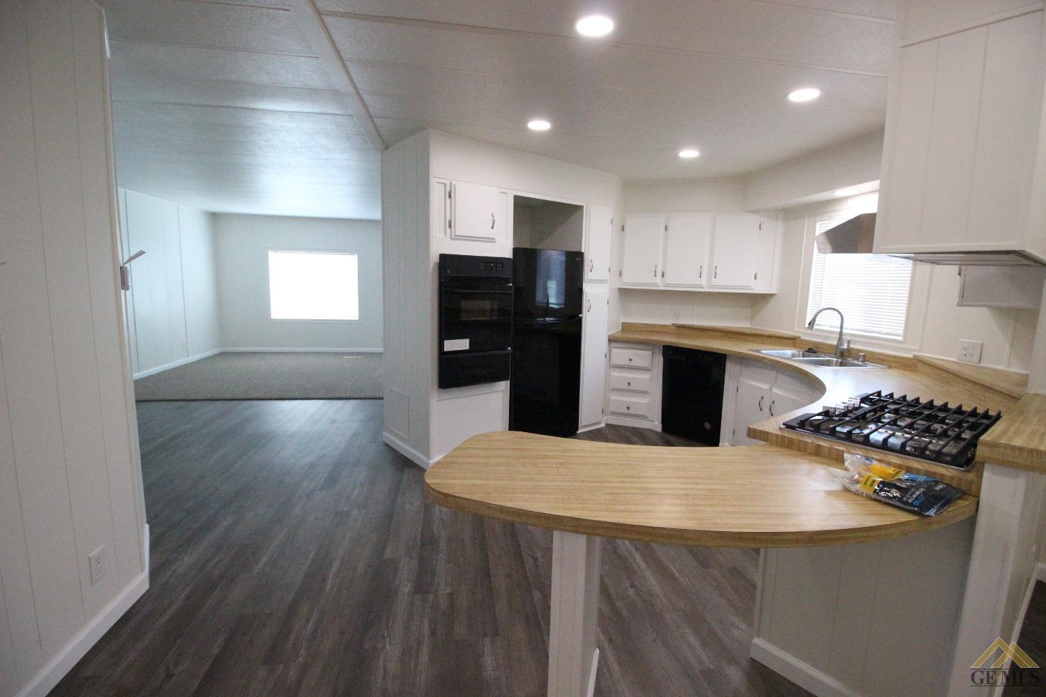 Undisclosed Address Bakersfield, CA 93308 - Photo 10 of 28 a kitchen with stainless steel appliances granite countertop a refrigerator a stove top oven a sink dishwasher and wooden floor
