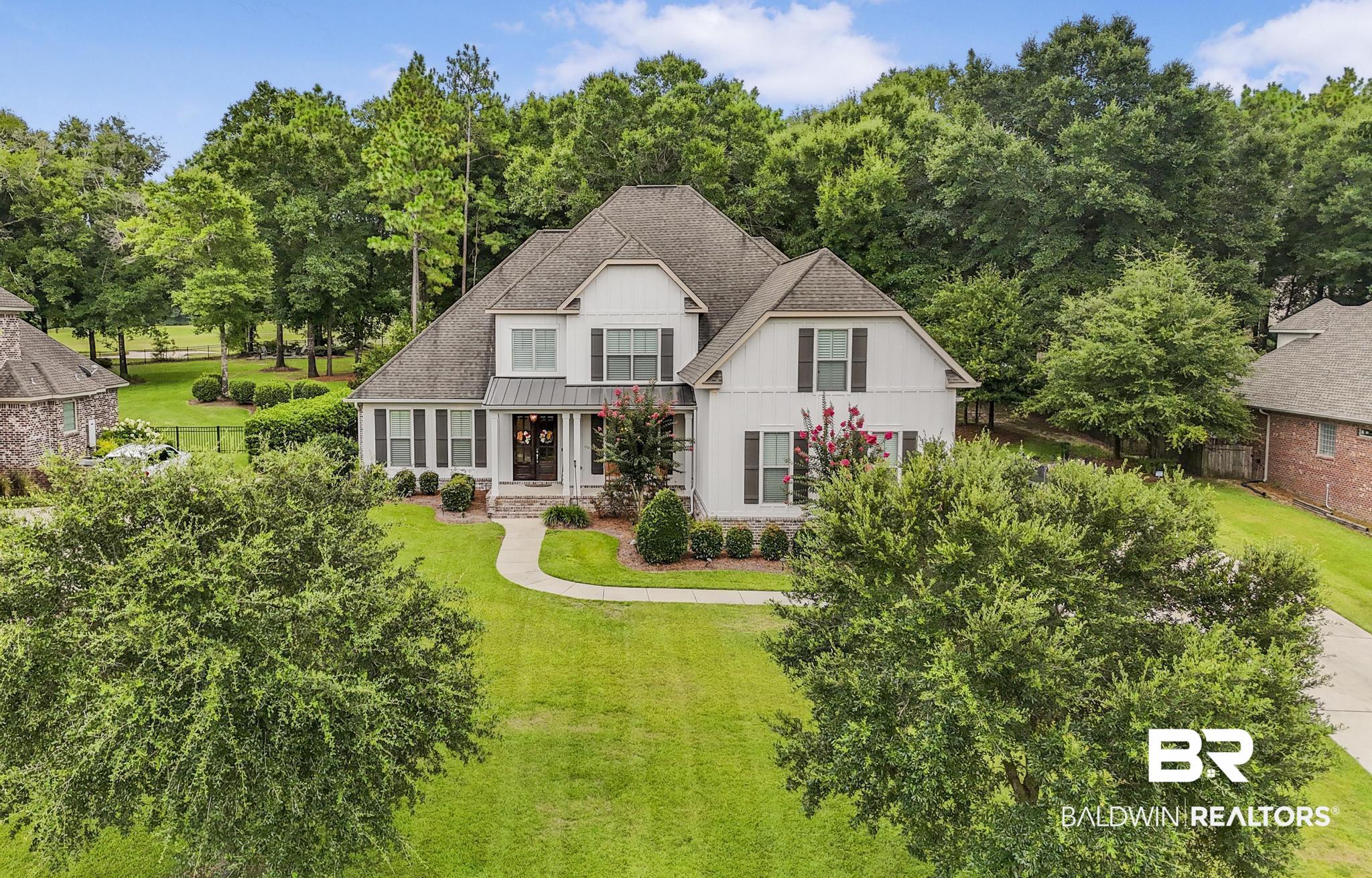 29949 Dolive Ridge Daphne, AL 36527 - Photo 1 of 55 Two-story residence featuring white siding and dark shutters, set on a verdant lawn with mature trees