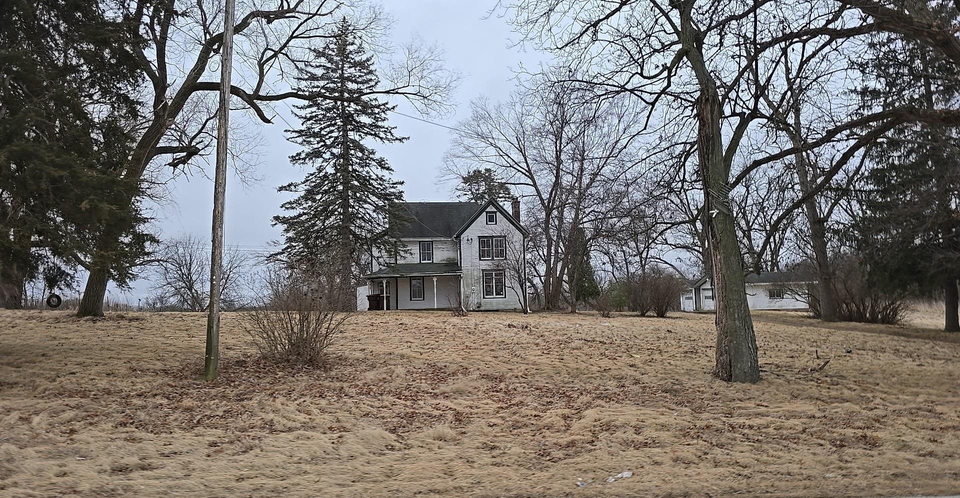 3319 East River Road Ridott, IL 61067 - Photo 2 of 15 a white house that has a tree in front of it