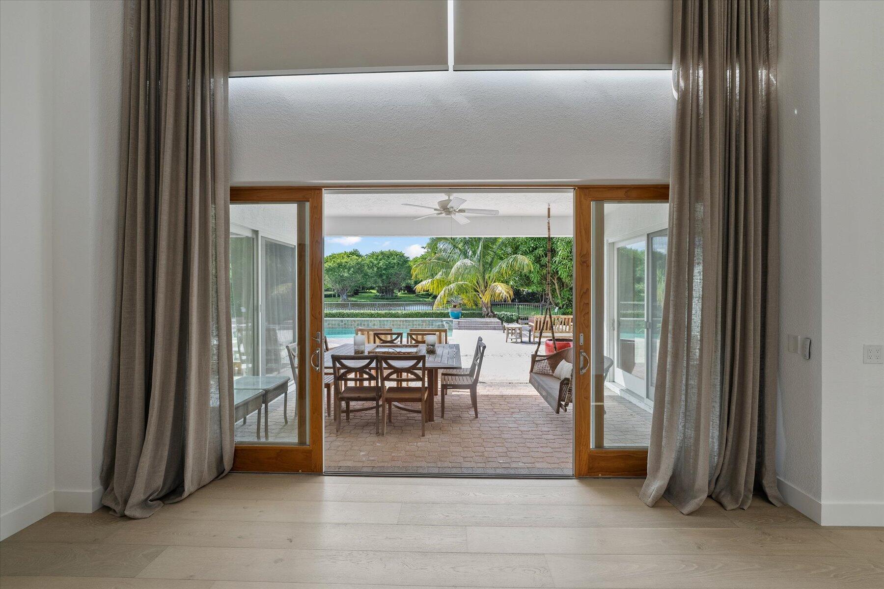 2821 Bent Cypress Road Wellington, FL 33414 - Photo 16 of 64 a dining room with furniture and a floor to ceiling window