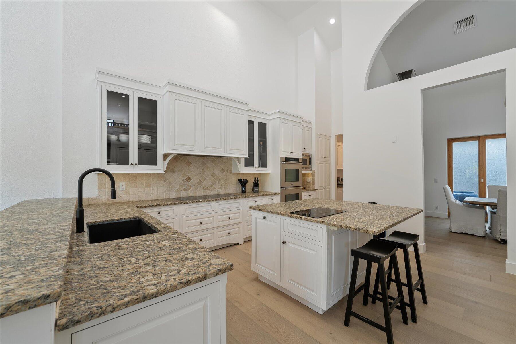 2821 Bent Cypress Road Wellington, FL 33414 - Photo 18 of 64 a kitchen with granite countertop a sink a stove and cabinets