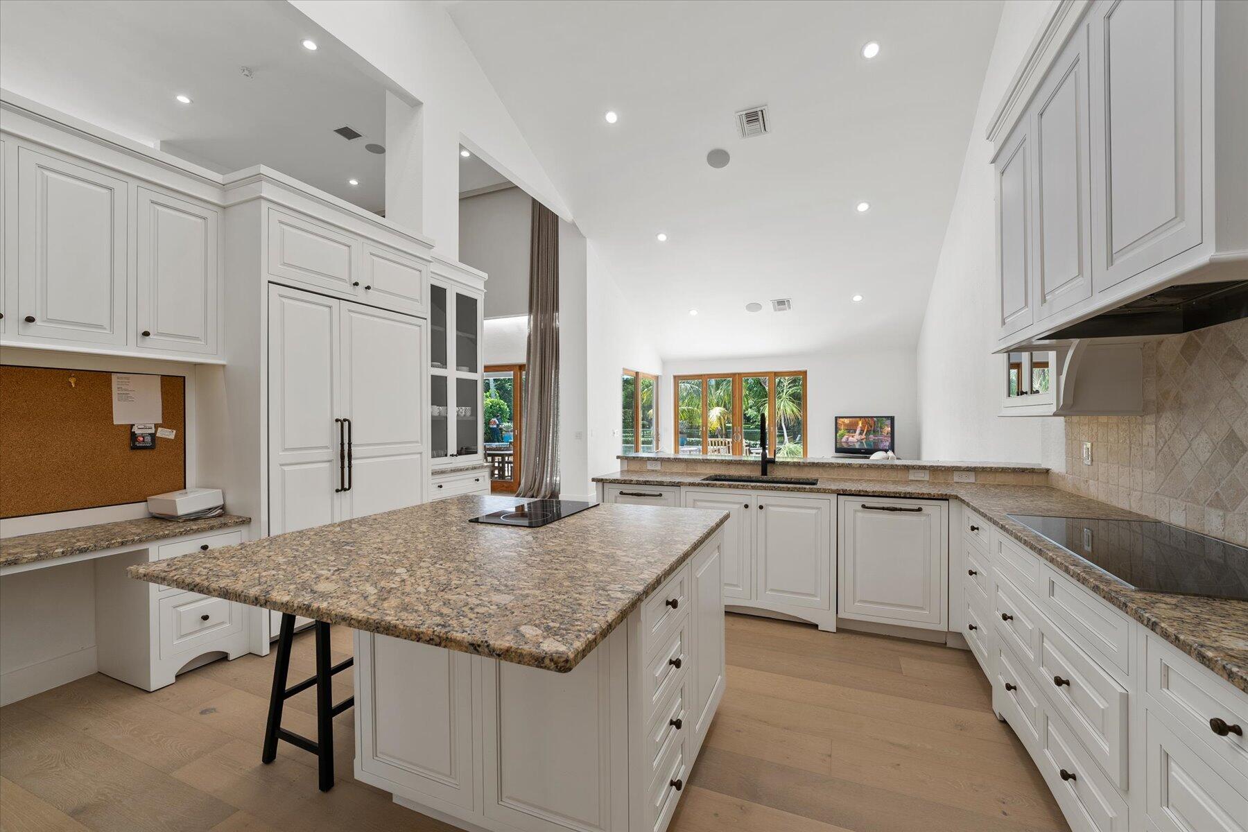 2821 Bent Cypress Road Wellington, FL 33414 - Photo 20 of 64 a kitchen with granite countertop kitchen island a sink stove and white cabinets