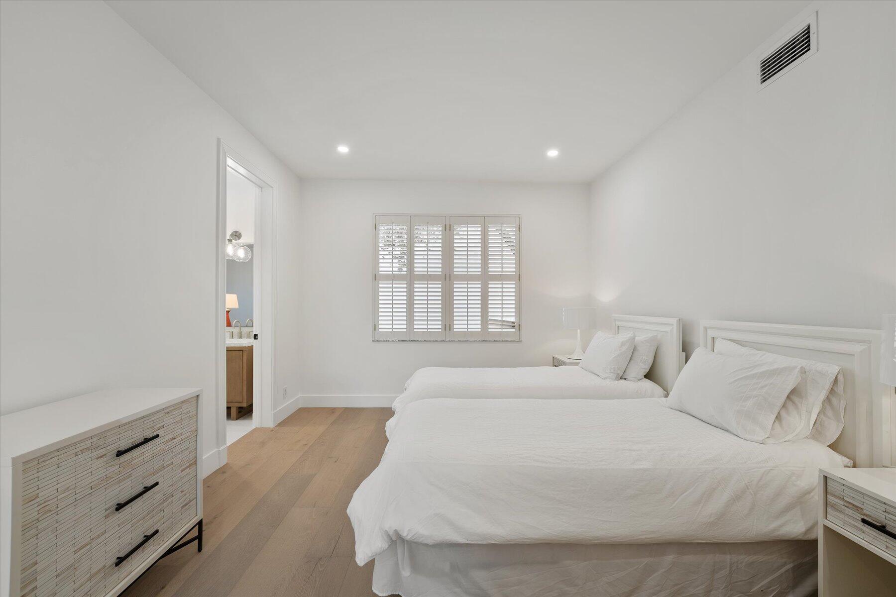 2821 Bent Cypress Road Wellington, FL 33414 - Photo 36 of 64 a large white bed in a white room with closet and mirror