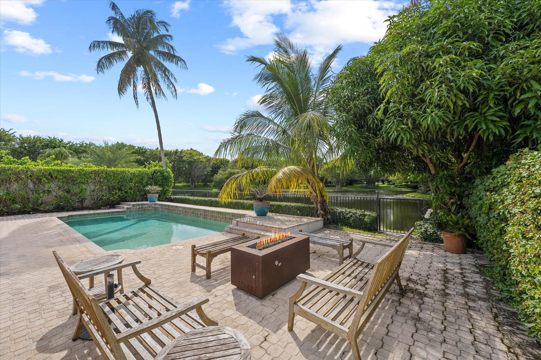 2821 Bent Cypress Road Wellington, FL 33414 - Photo 56 of 64 a view of a patio with table and chairs potted plants with wooden floor and fence