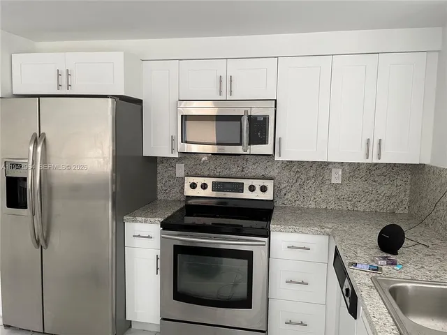 a kitchen with stainless steel appliances a stove a microwave and a refrigerator