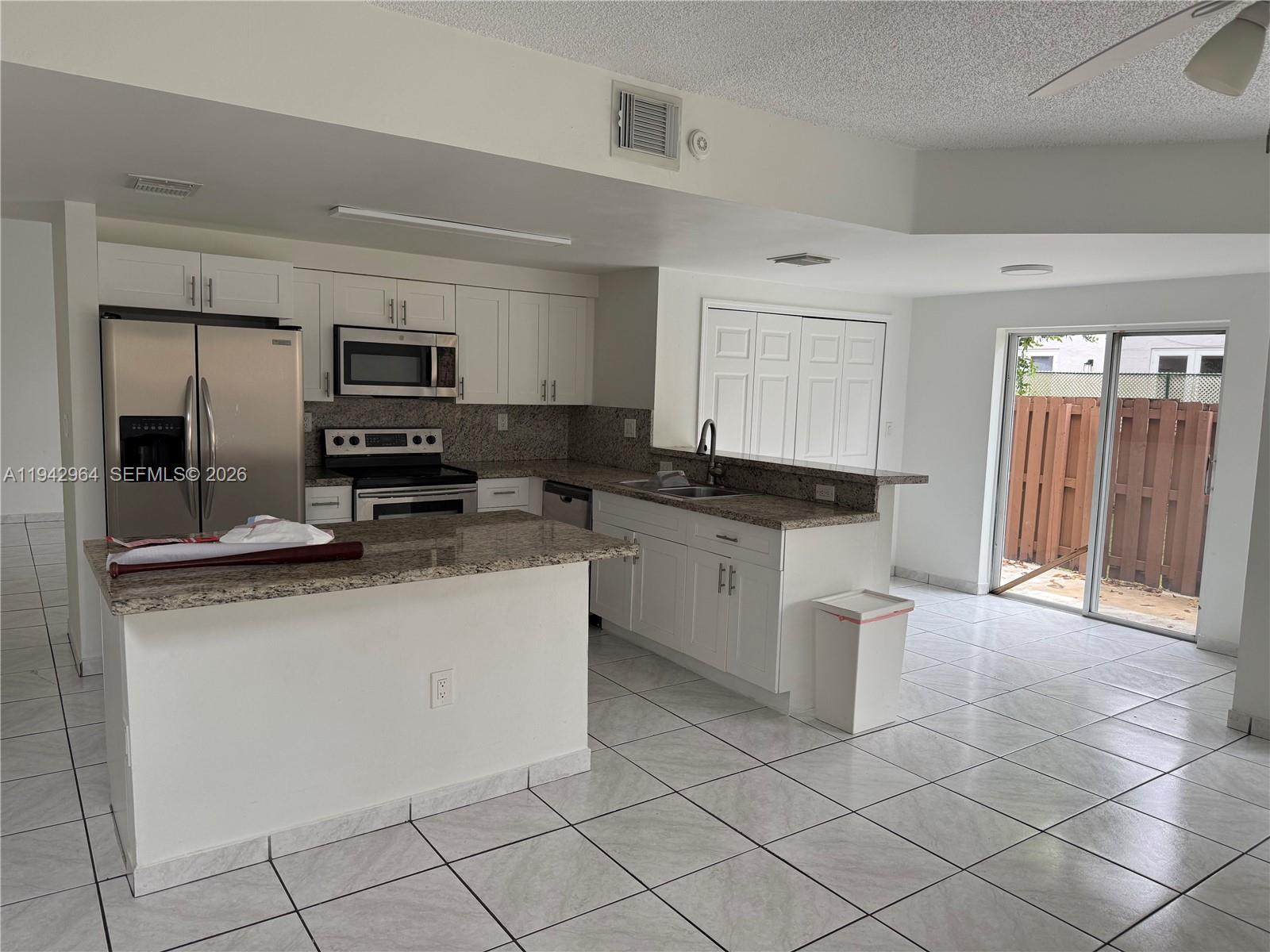 15870 Southwest 85th Lane Miami, FL 33193 - Photo 3 of 18 a kitchen with white cabinets a sink and appliances