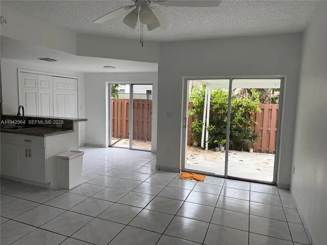 a view of a livingroom with a floor to ceiling window and kitchen