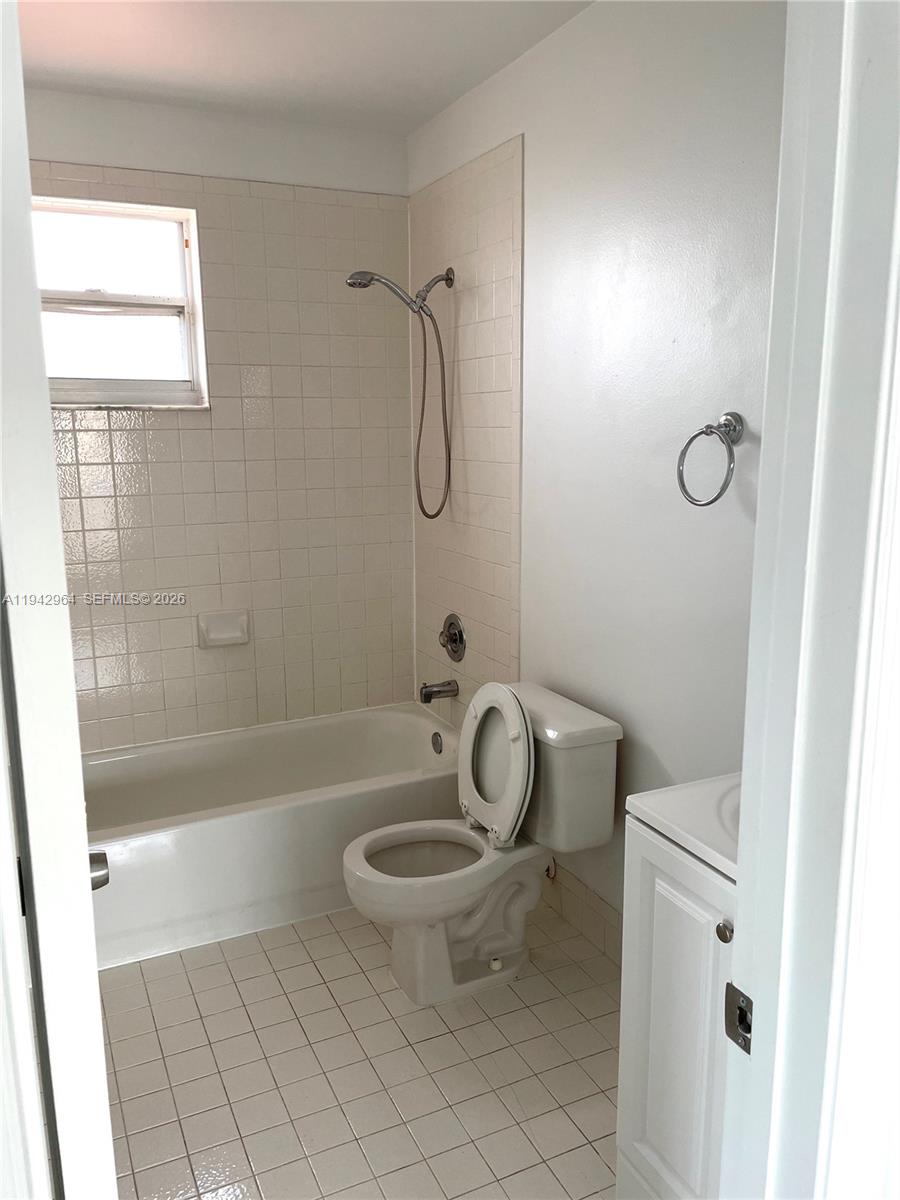 15870 Southwest 85th Lane Miami, FL 33193 - Photo 9 of 18 a bathroom with a granite countertop toilet a sink a mirror and shower