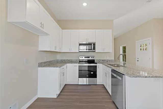 a kitchen with granite countertop cabinets stainless steel appliances and a counter space