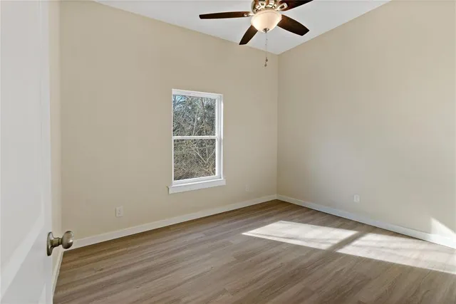 an empty room with a window and a fan
