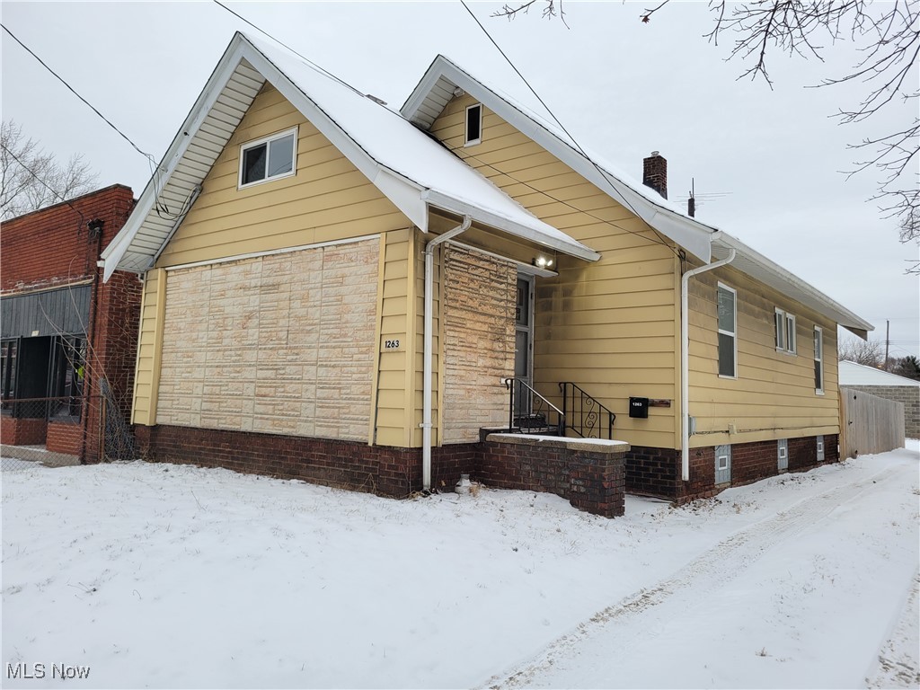 Snow covered property featuring a chimney