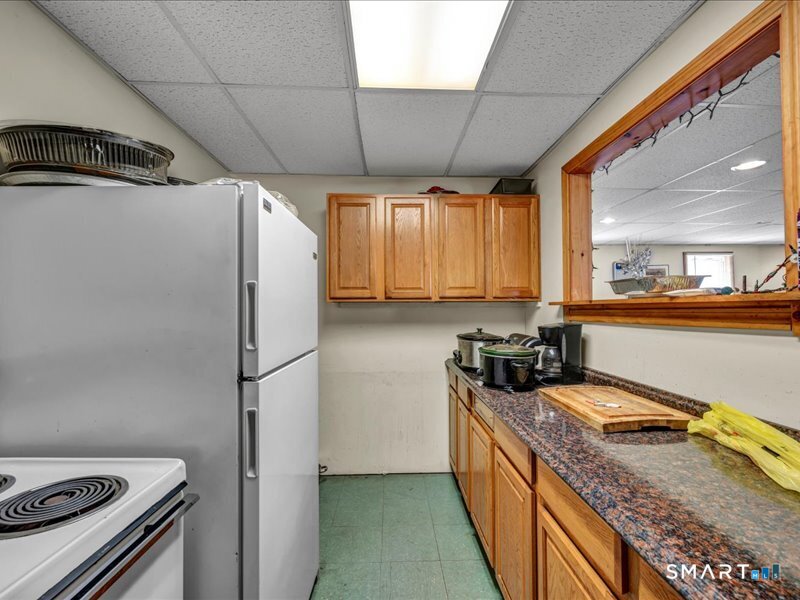 61 Maple Avenue Wallingford, CT 06492 - Photo 7 of 20 a kitchen with a refrigerator a stove a sink dishwasher and wooden cabinets