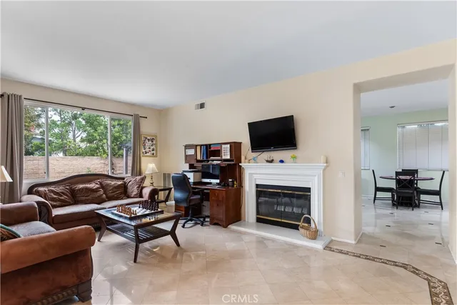 a living room with furniture a fireplace and a flat screen tv