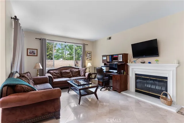 a living room with furniture a flat screen tv and a fireplace