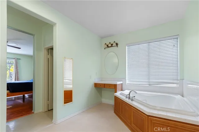 a bathroom with a tub sink and mirror
