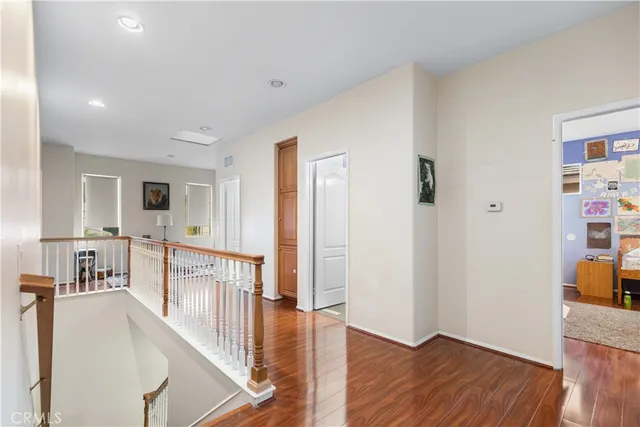 a view of a hallway with wooden floor and dining room