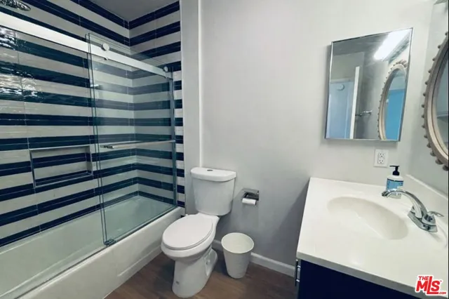 a utility room with wooden floor washer and dryer