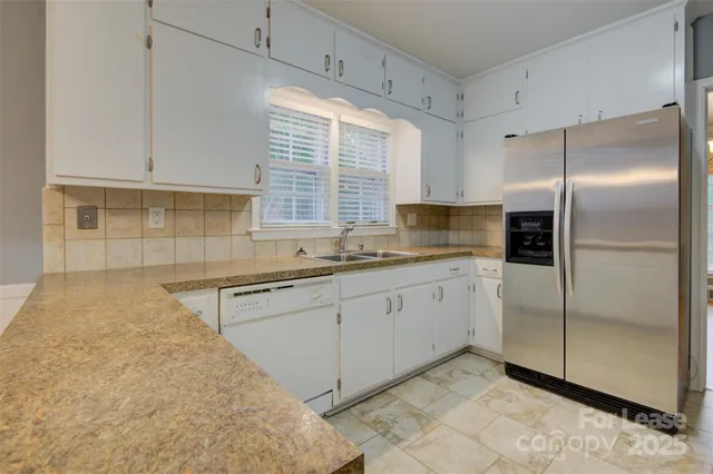 a kitchen with granite countertop a sink stainless steel appliances and cabinets
