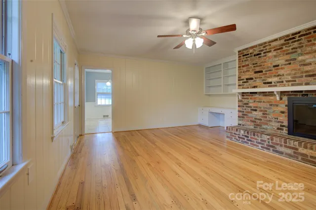 a view of empty room with a fireplace and wooden floor