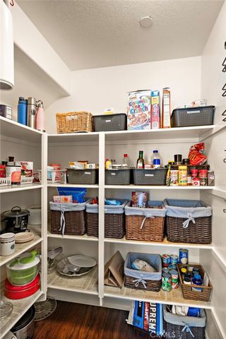 a cabinet with stainless steel appliances lots of different kinds of food